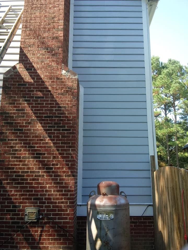 A propane tank on the side of a brick house