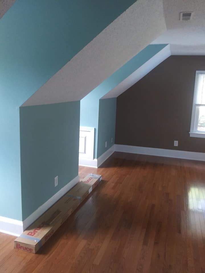 An empty room with hardwood floors and blue walls.