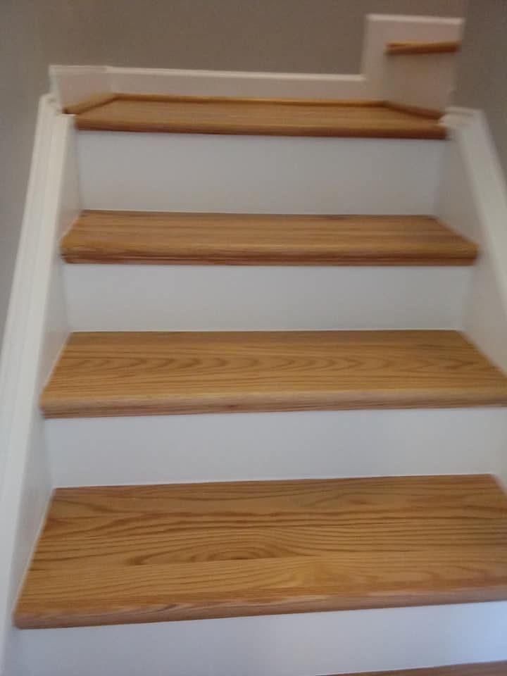 A close up of a set of wooden stairs with white steps.