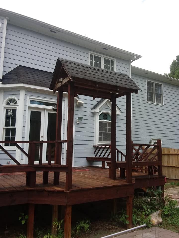 A blue house with a wooden deck in front of it