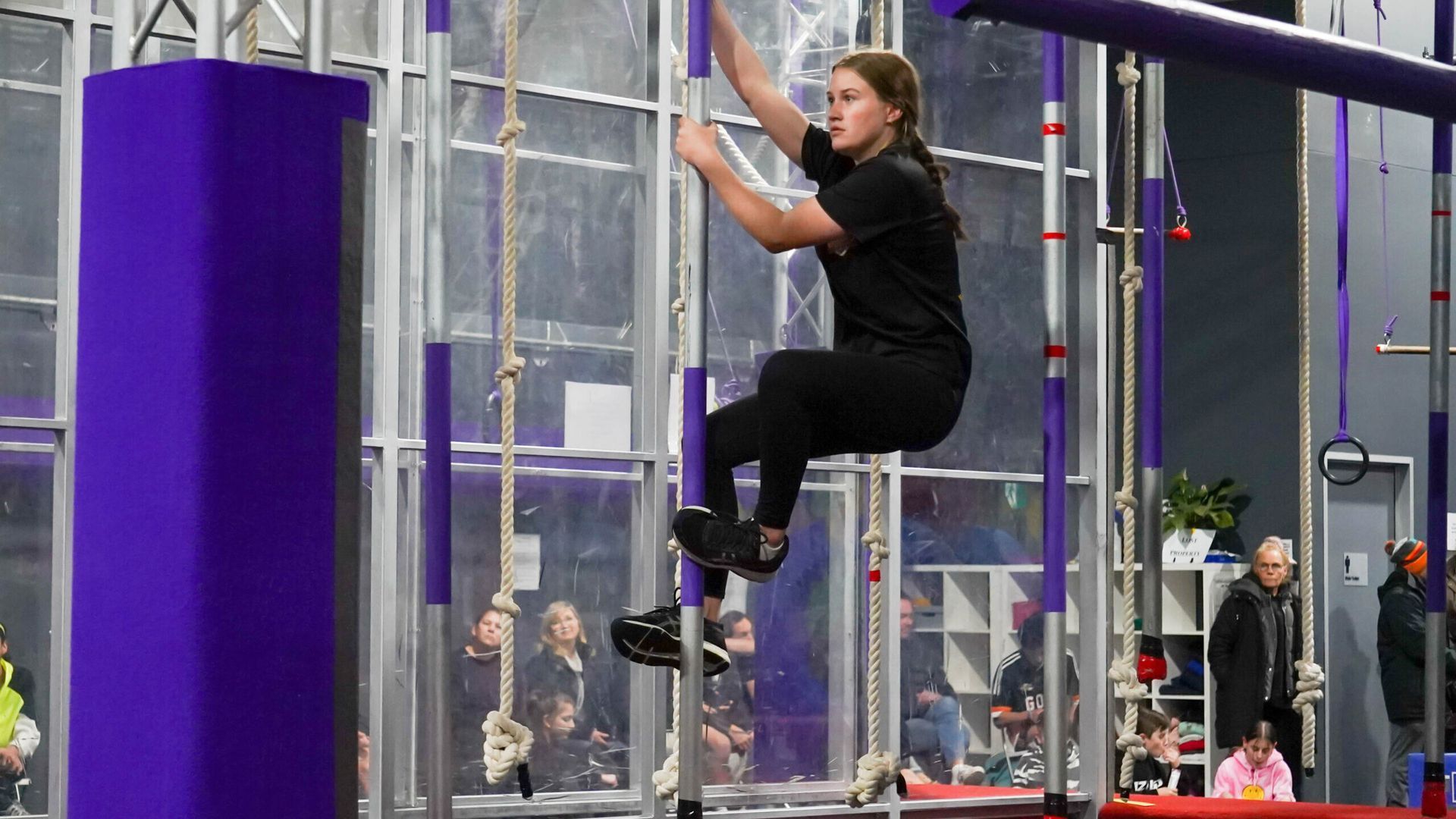 Two people in martial arts uniforms bowing to each other in a bright room.