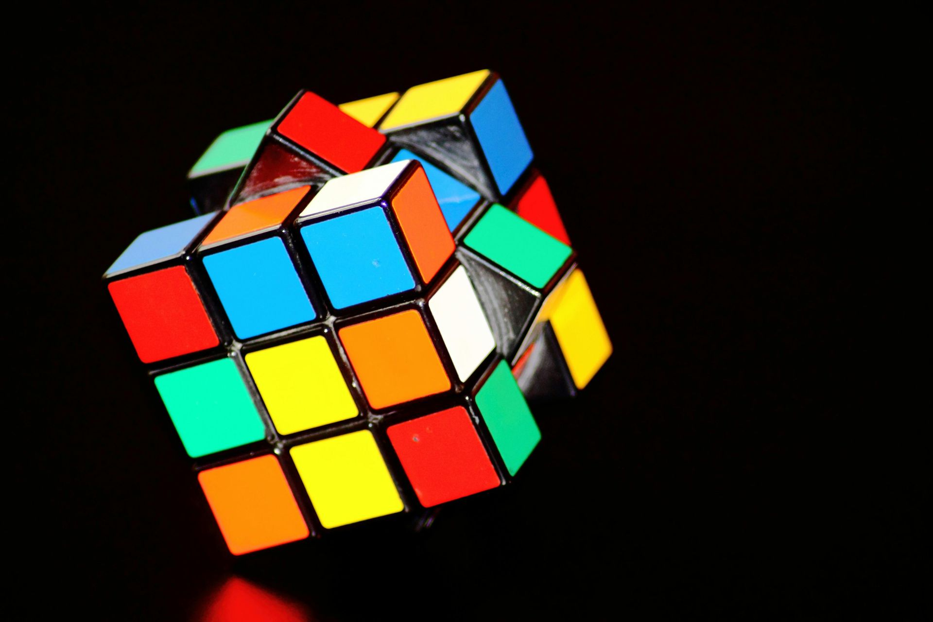 Um cubo mágico colorido em um fundo preto