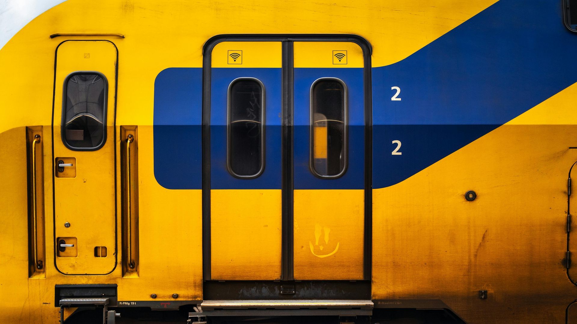 Um trem amarelo e azul com o número 2 na porta.