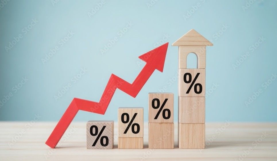 Wooden blocks with percentage signs, a red upward arrow, and a house, symbolizing rising percentages.