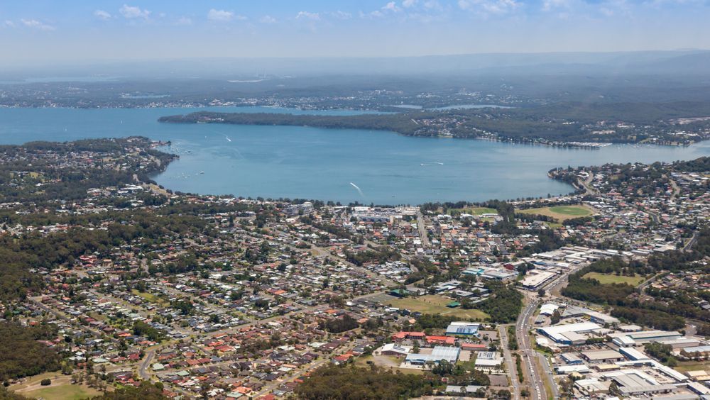 Aerial View of a Lakeside Town With Buildings, Roads, and Trees — Darren Smith Roofing In New Lambton, NSW