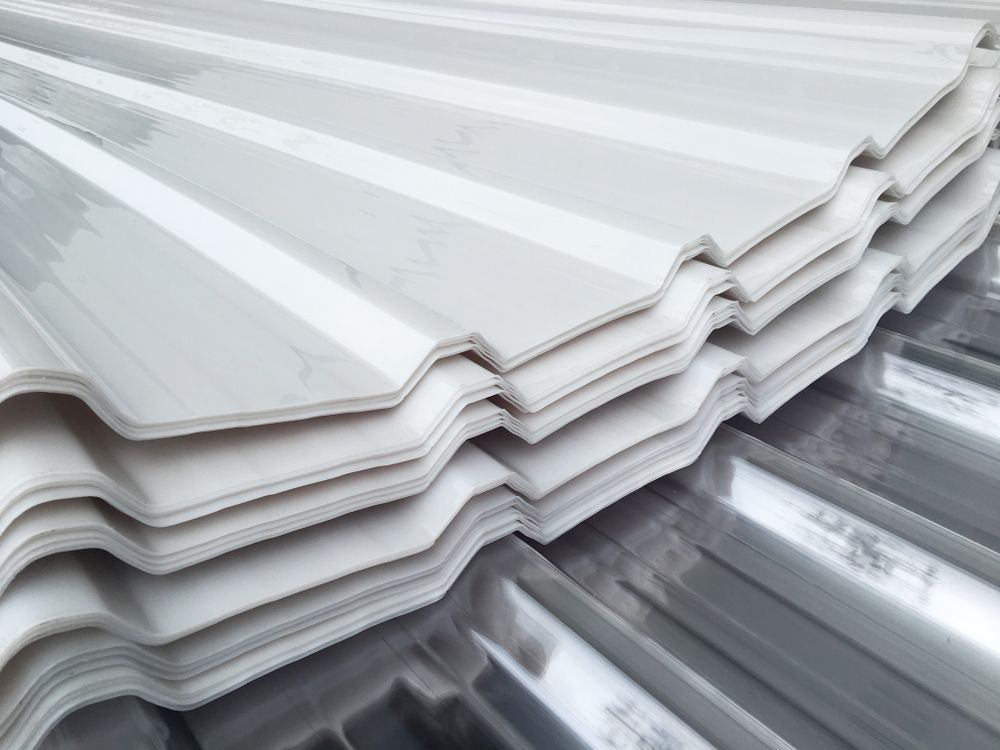 White Corrugated Roofing Sheets Stacked on Top of Metal Roofing — Darren Smith Roofing In Glendale, NSW