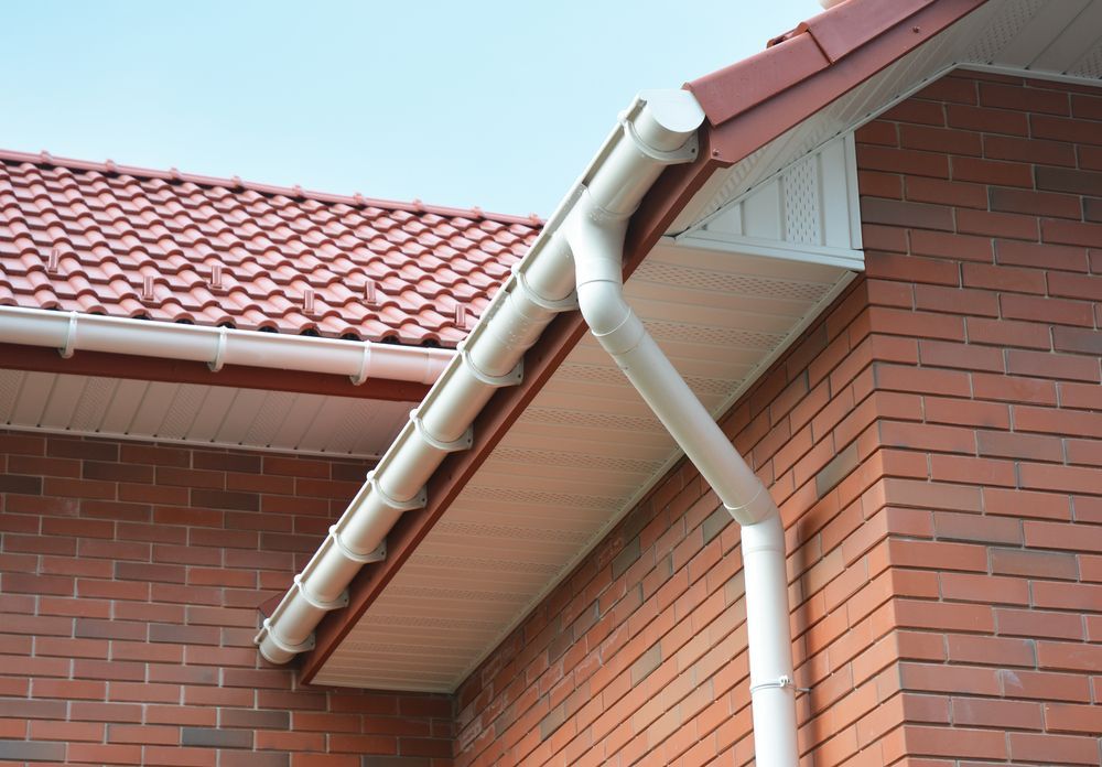 White Rain Gutter System on a Brick House With Red Tile Roof — Darren Smith Roofing In Kotara, NSW
