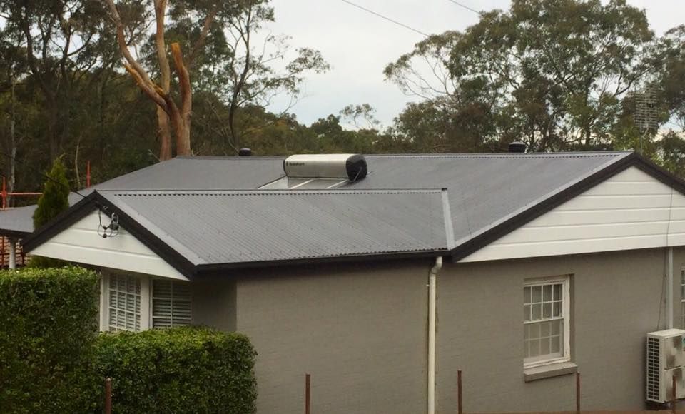 Grey House With Corrugated Metal Roof, Solar Water Heater — Darren Smith Roofing In Merewether, NSW