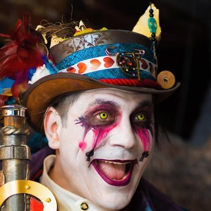 A man wearing a top hat with feathers on it