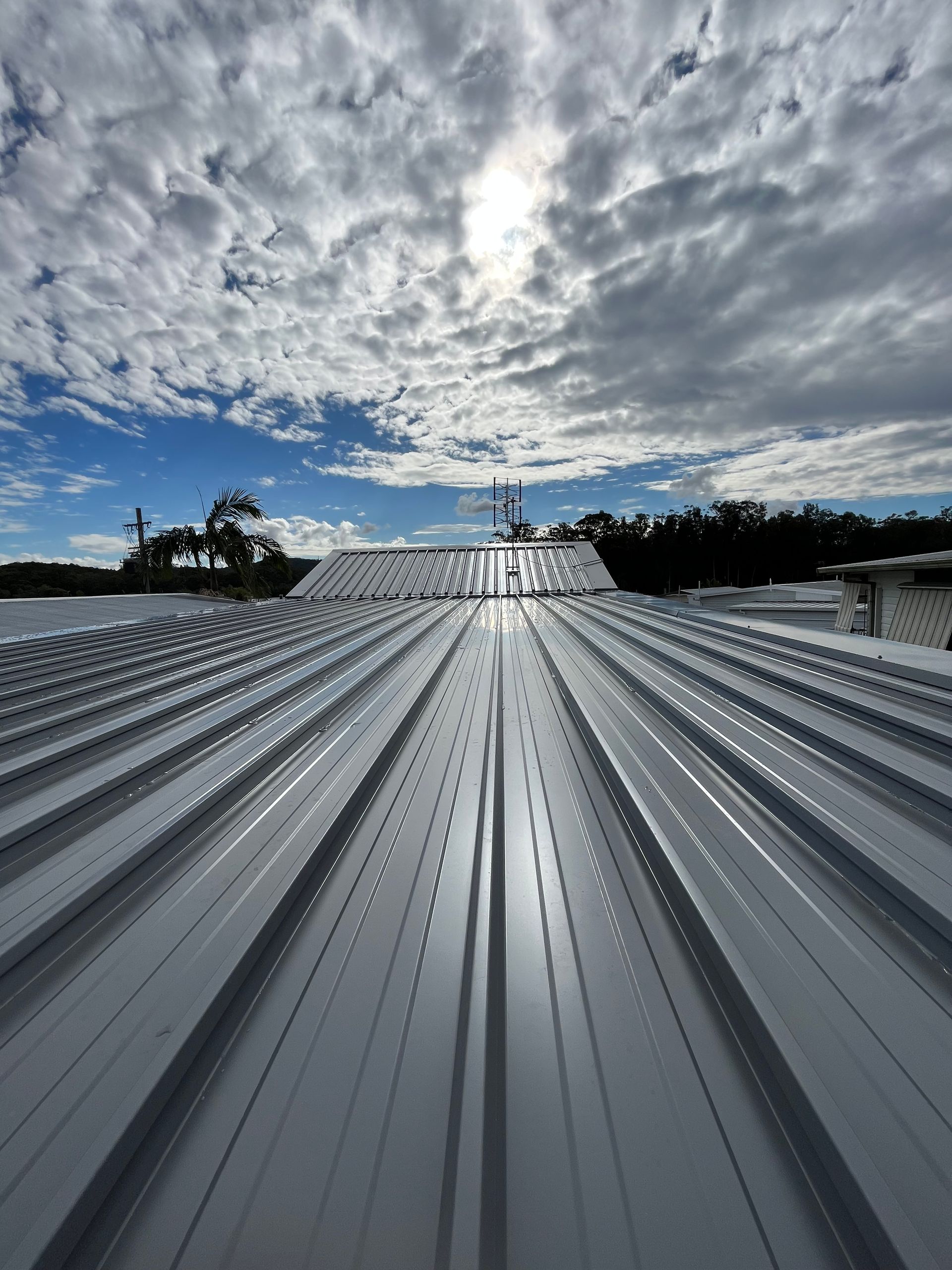 The sun is shining through the clouds on the roof of a building