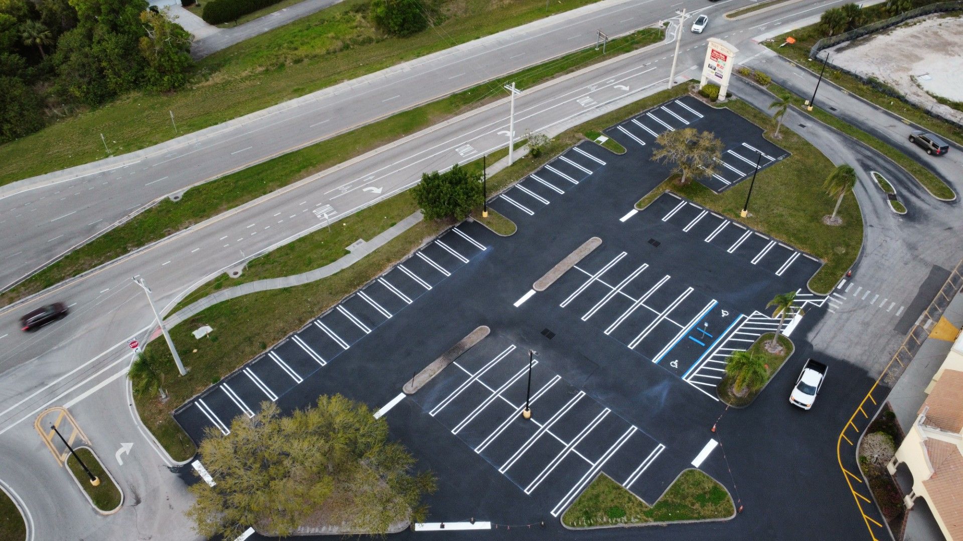 An aerial view of a parking lot next to a road.
