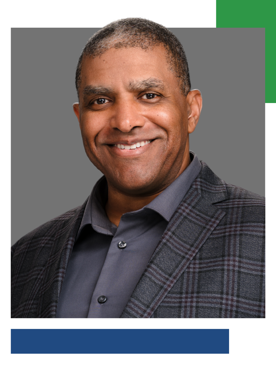 Smiling man in a gray shirt and checkered blazer against a gray background with green and blue accents.