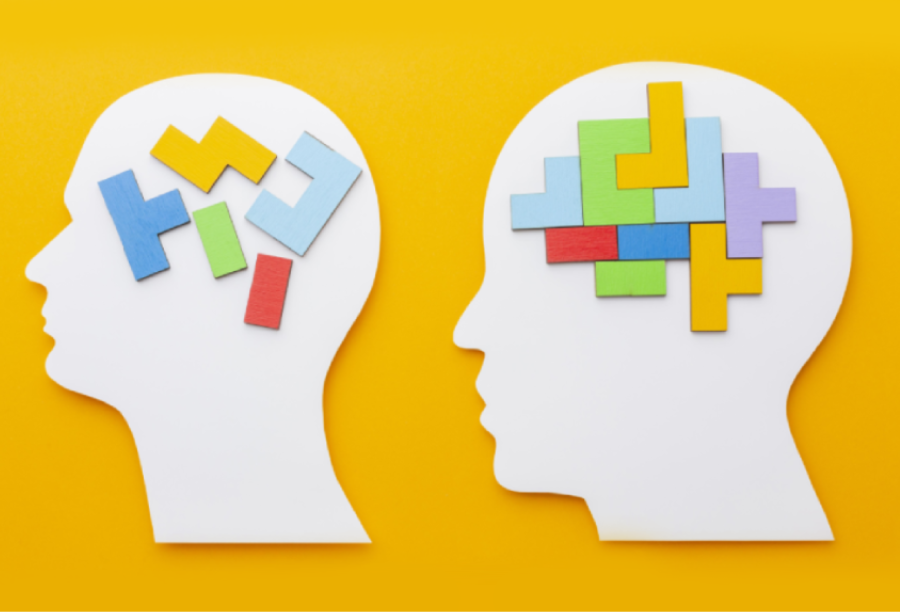 Two white head silhouettes, one with scattered puzzle pieces inside, the other with a completed puzzle.