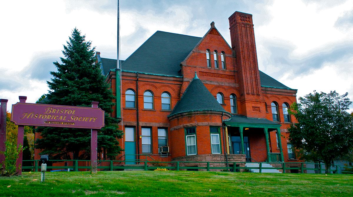 A large red brick building with a welcome sign in front of it