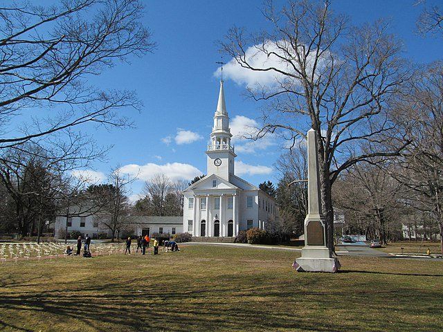 A church with a steeple in the middle of a park