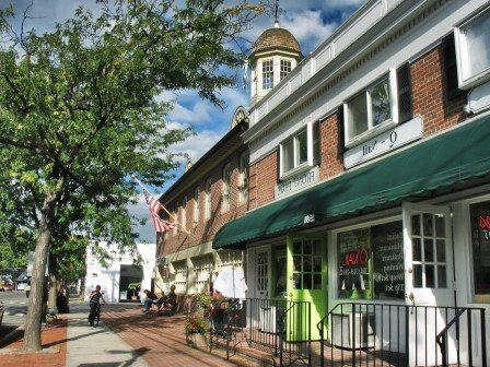 A brick building with a green awning that says j & j