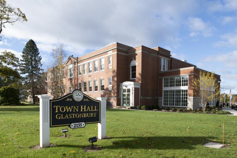 A sign in front of a brick building that says town hall glastonbury