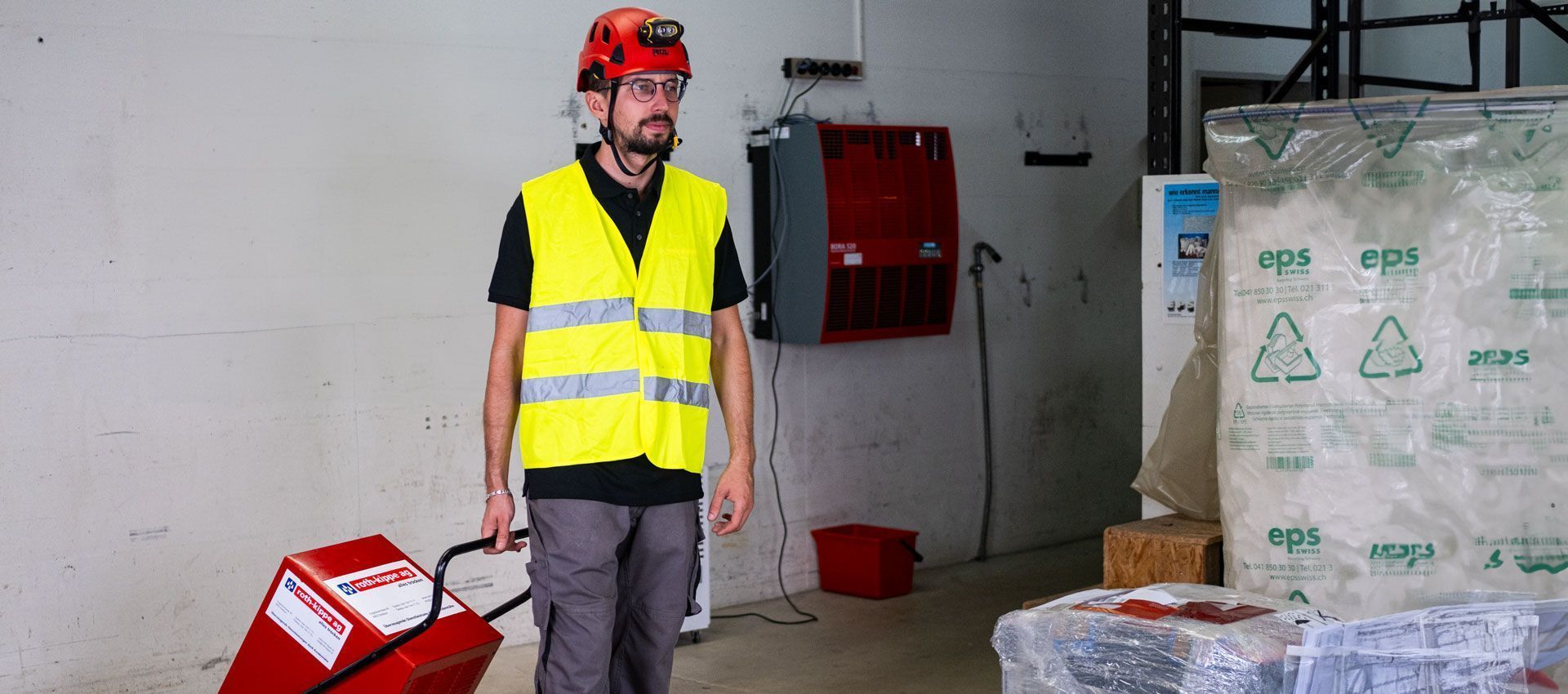 Ein Mann hält ein rotes Trocknungsgerät in der Hand