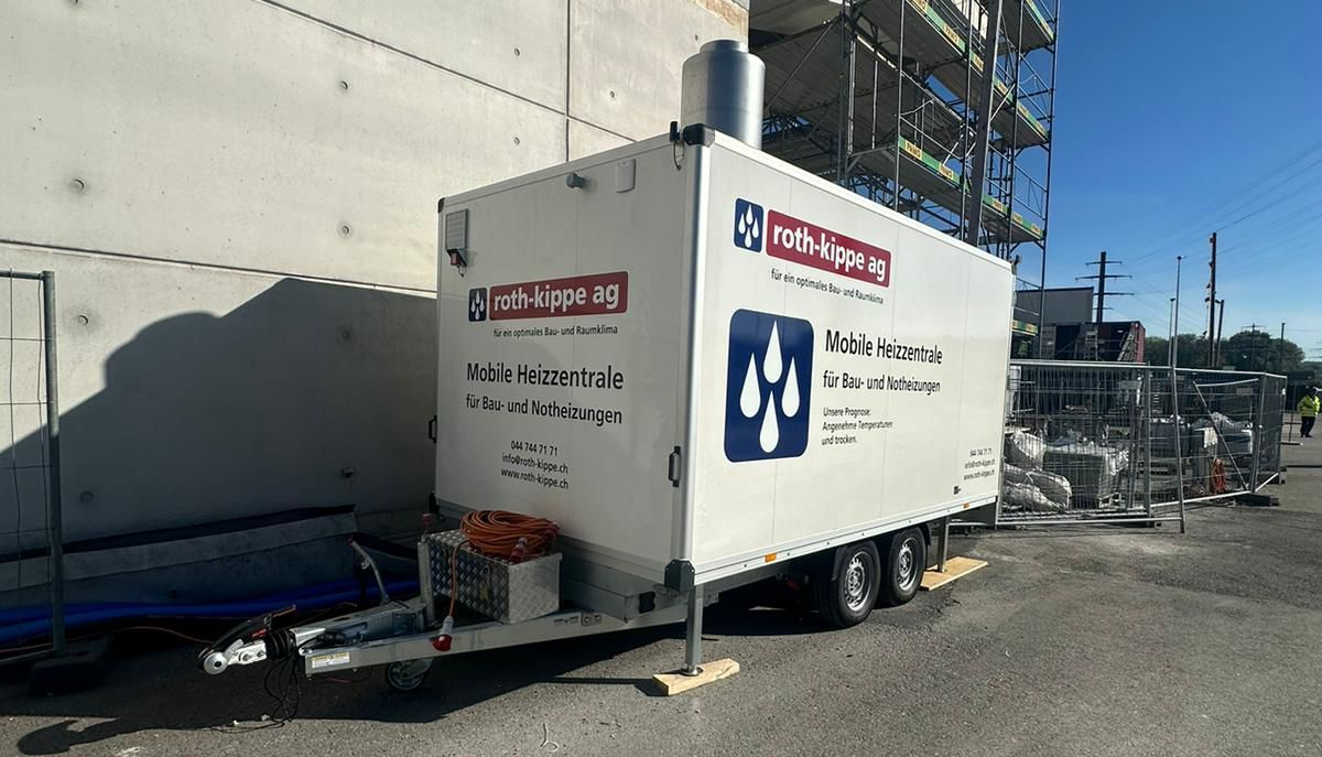 Eine mobile Heizungszentrale vor einer Baustelle
