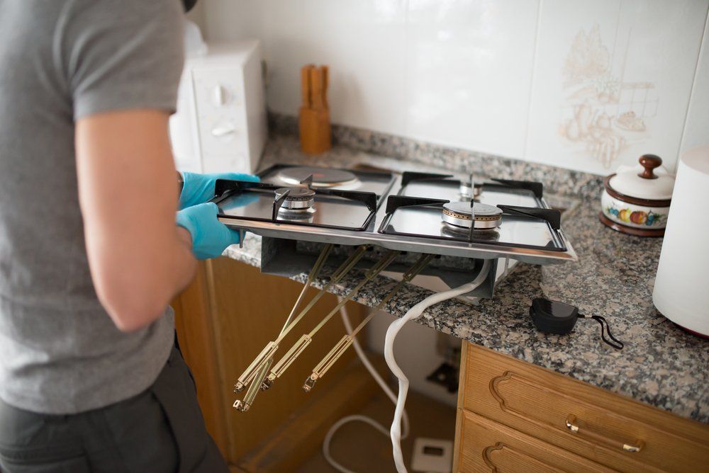 A Coffs Harbour Gas Fitter Installing A Gas Stove Top — Gasfitters in Coffs Harbour, NSW