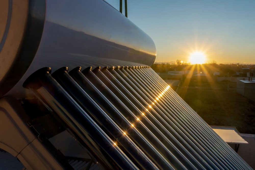 Solar Water Heater On The Roof At Sunset