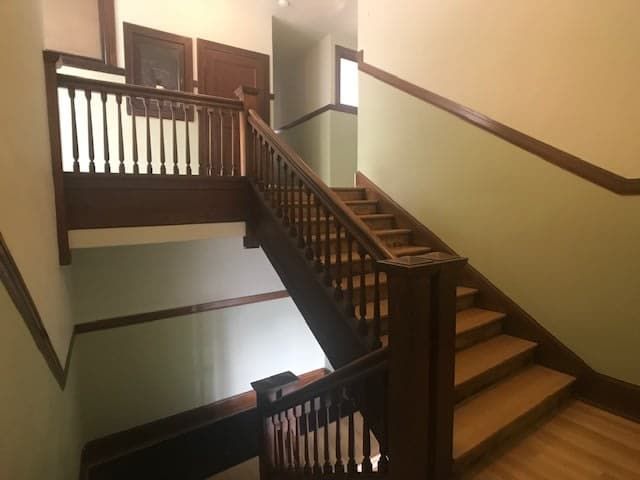 A staircase in a building with a wooden railing