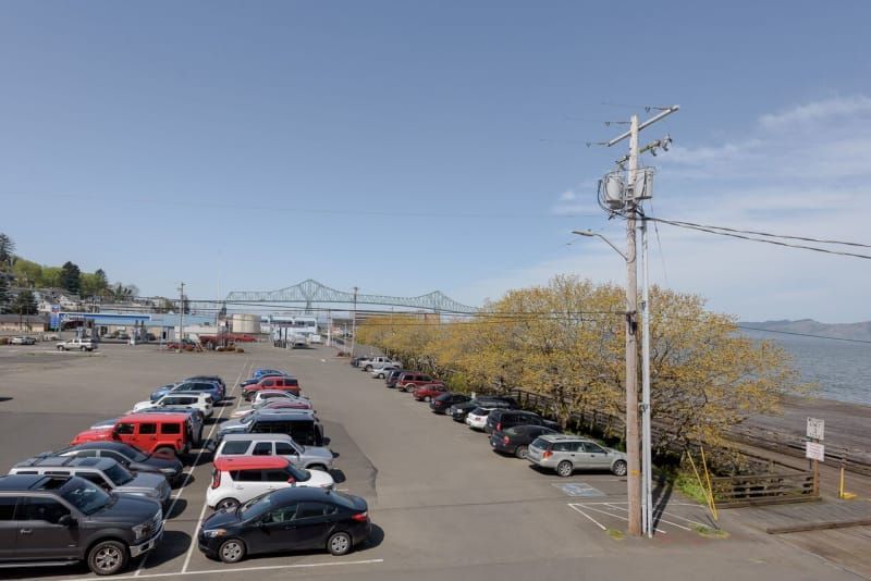 A lot of cars are parked in a parking lot next to a body of water.