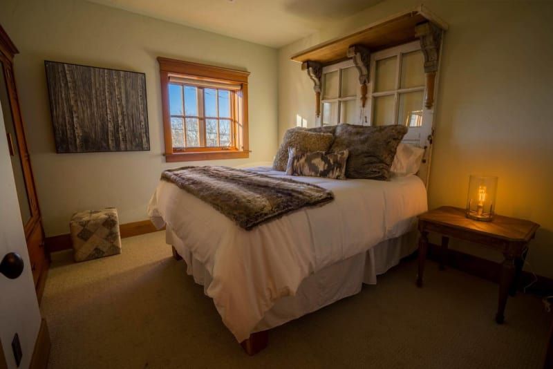 A bedroom with a bed , nightstand , and window.