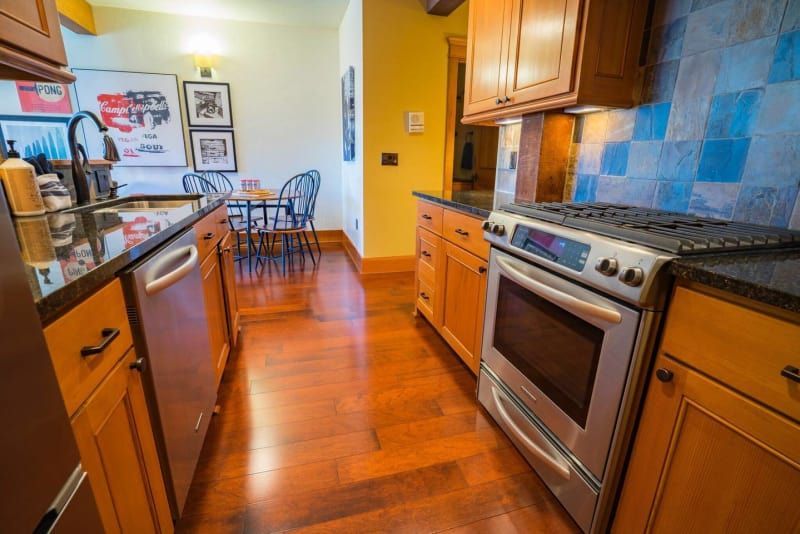 A kitchen with stainless steel appliances and wooden cabinets.