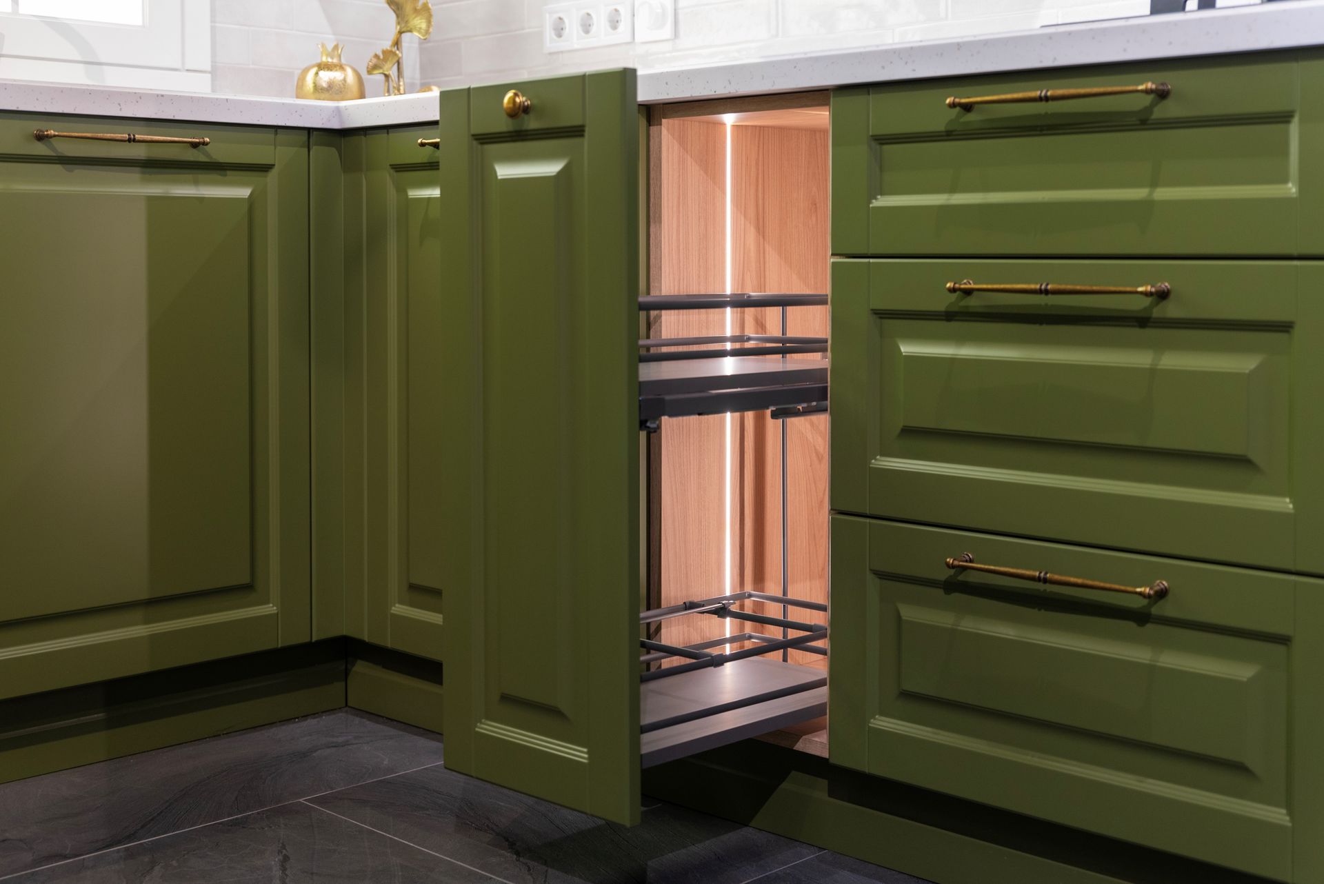 Open a drawer in a green kitchen cabinet. Open a drawer in a green kitchen cabinet.
