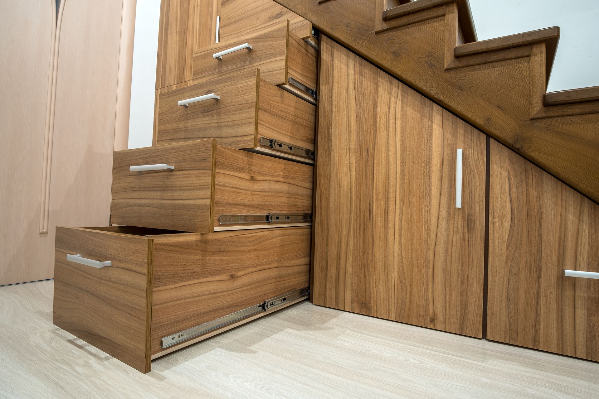 Custom-built pullout cabinets on glides in slots under stairs. Custom-built pullout cabinets on glides in slots under stairs.