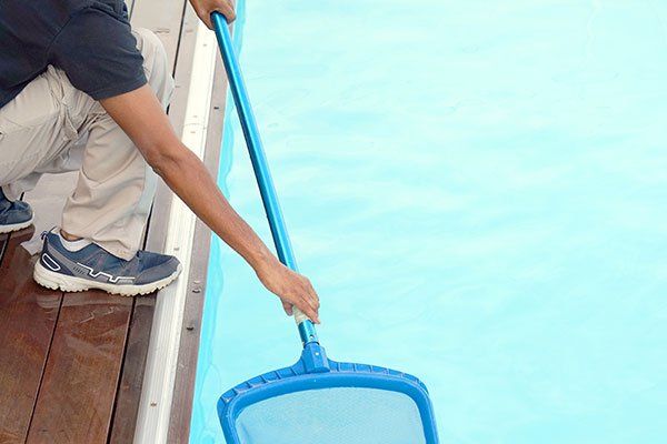 Pool Accessories — Worker Cleaning the Pool in Northshore Chicago, IL