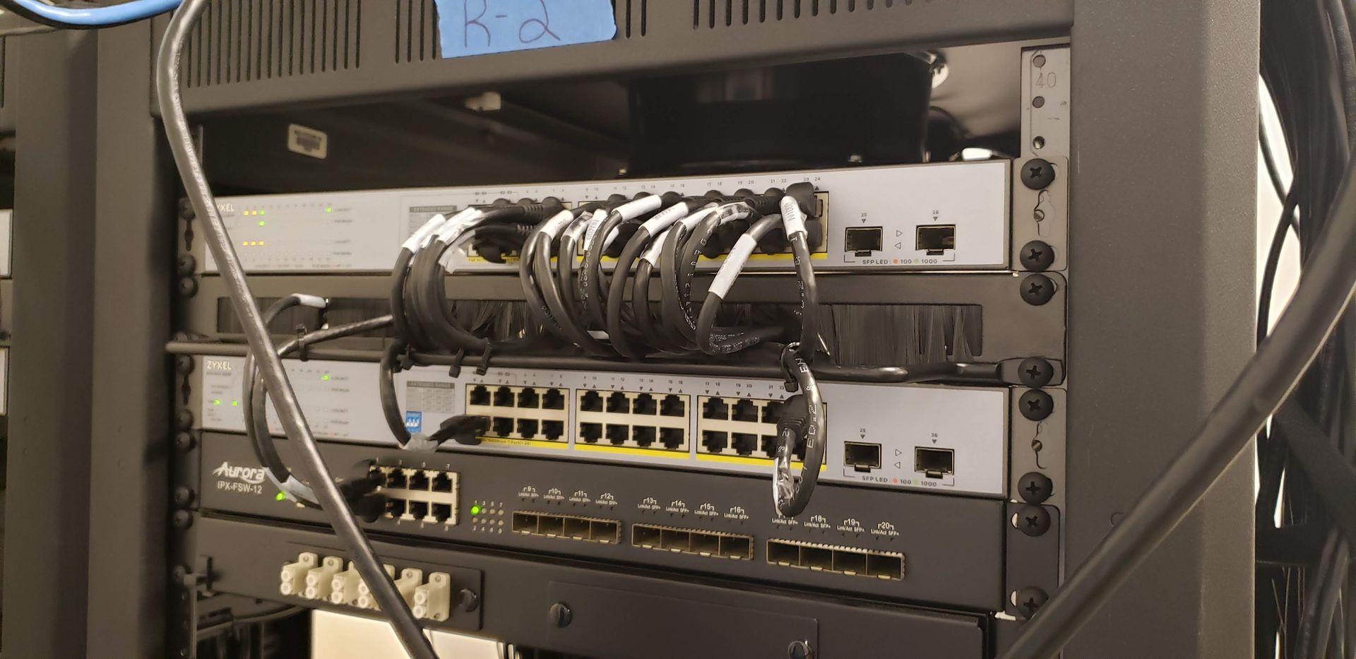 A server rack with a lot of wires coming out of it.