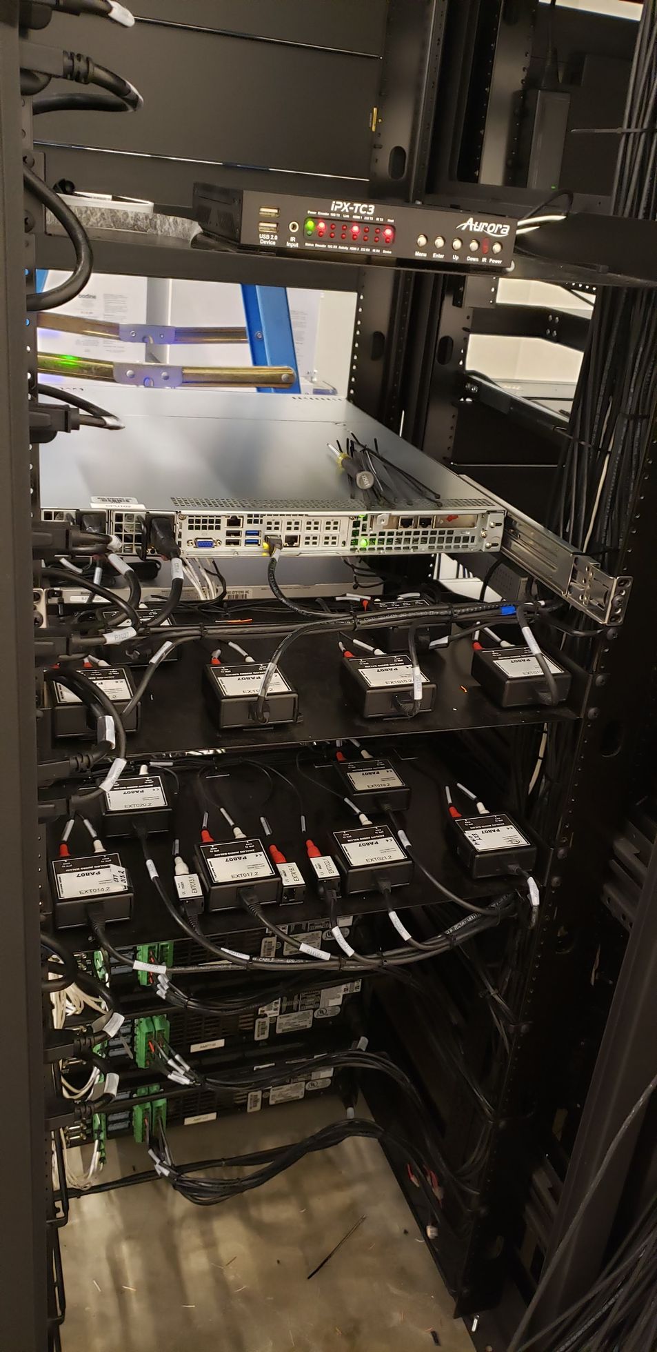 A server rack with a lot of wires coming out of it.