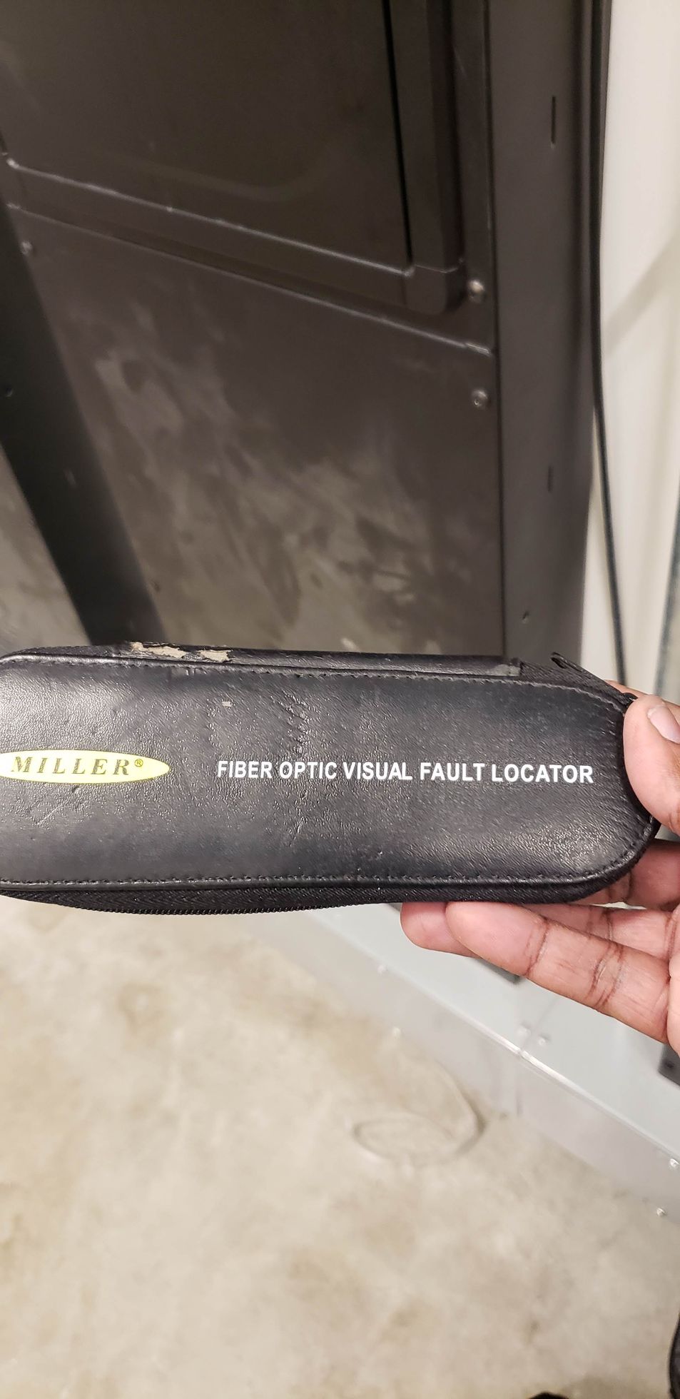 A person is holding a black object in their hand.