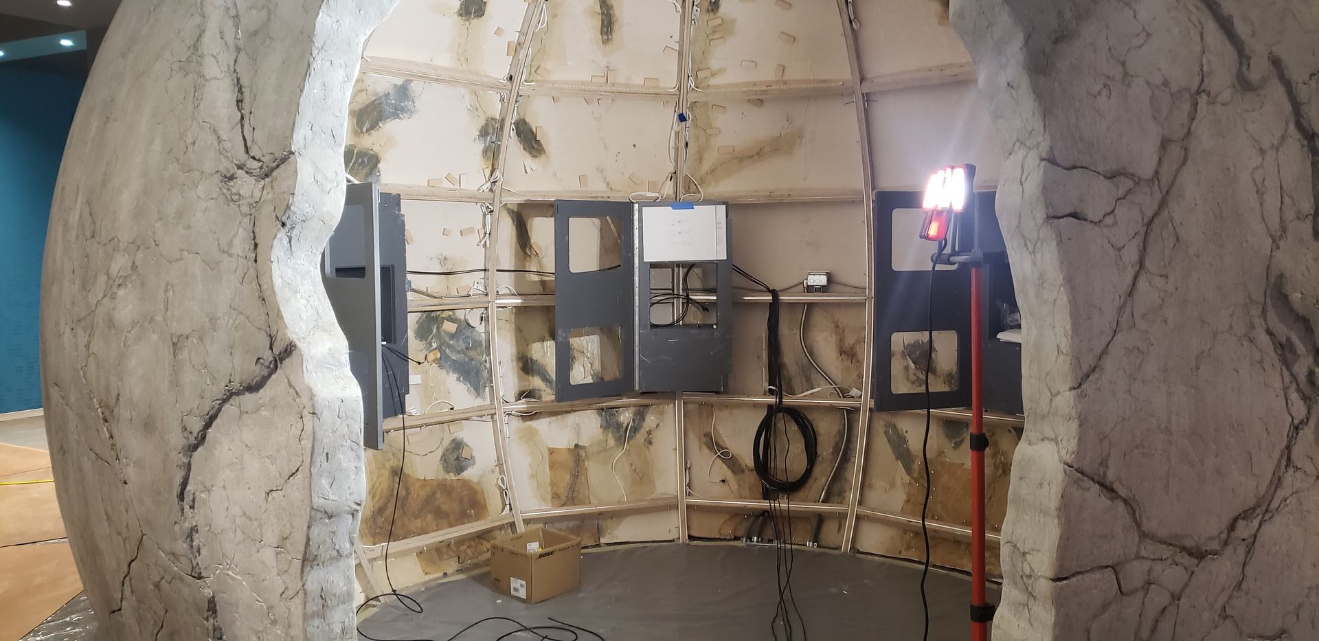 A light is shining through a hole in a wall.