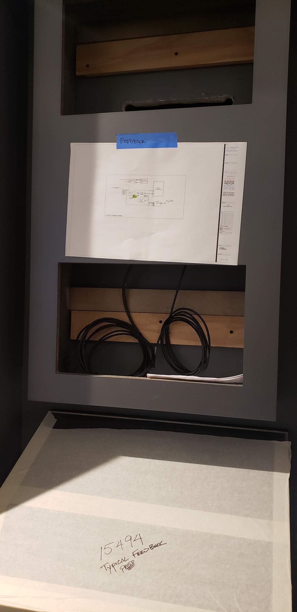 A shelf with a drawing on it and a bunch of wires coming out of it.