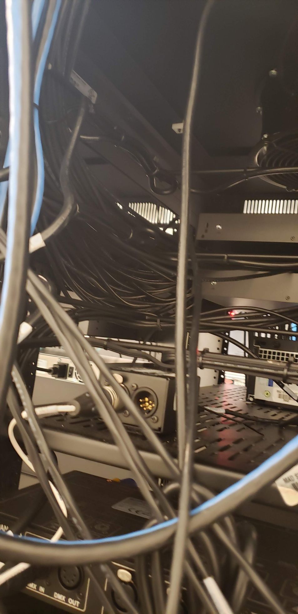 A bunch of wires are hanging from a rack in a room.