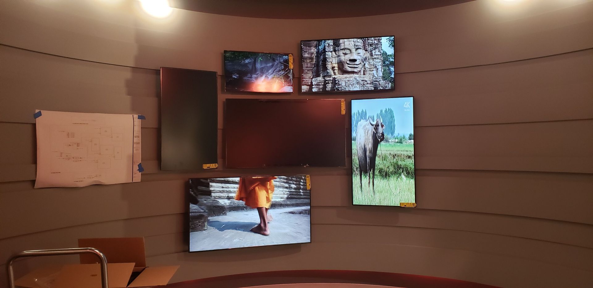 A room with a lot of televisions on the wall