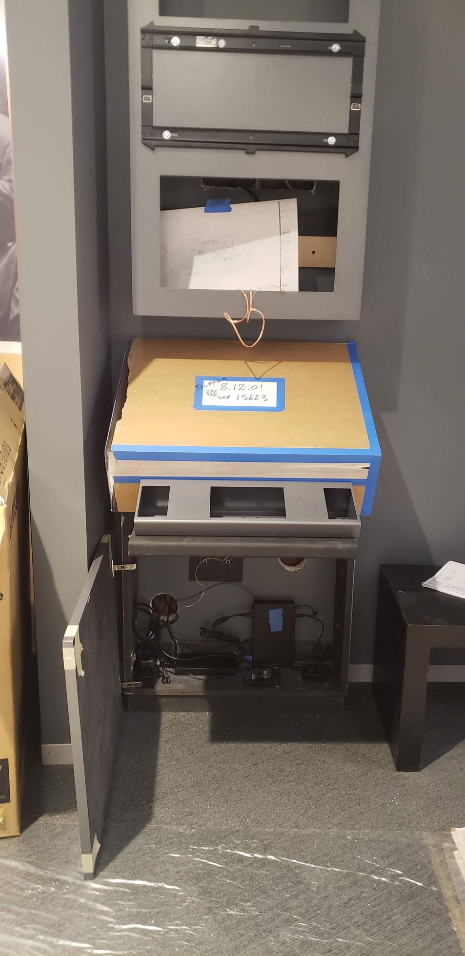 A computer is sitting on top of a wooden table in a room.