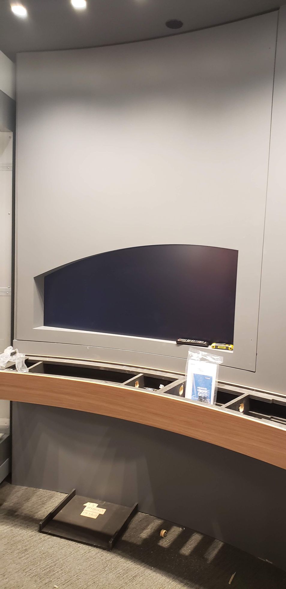 A room with a gray wall and a wooden table.