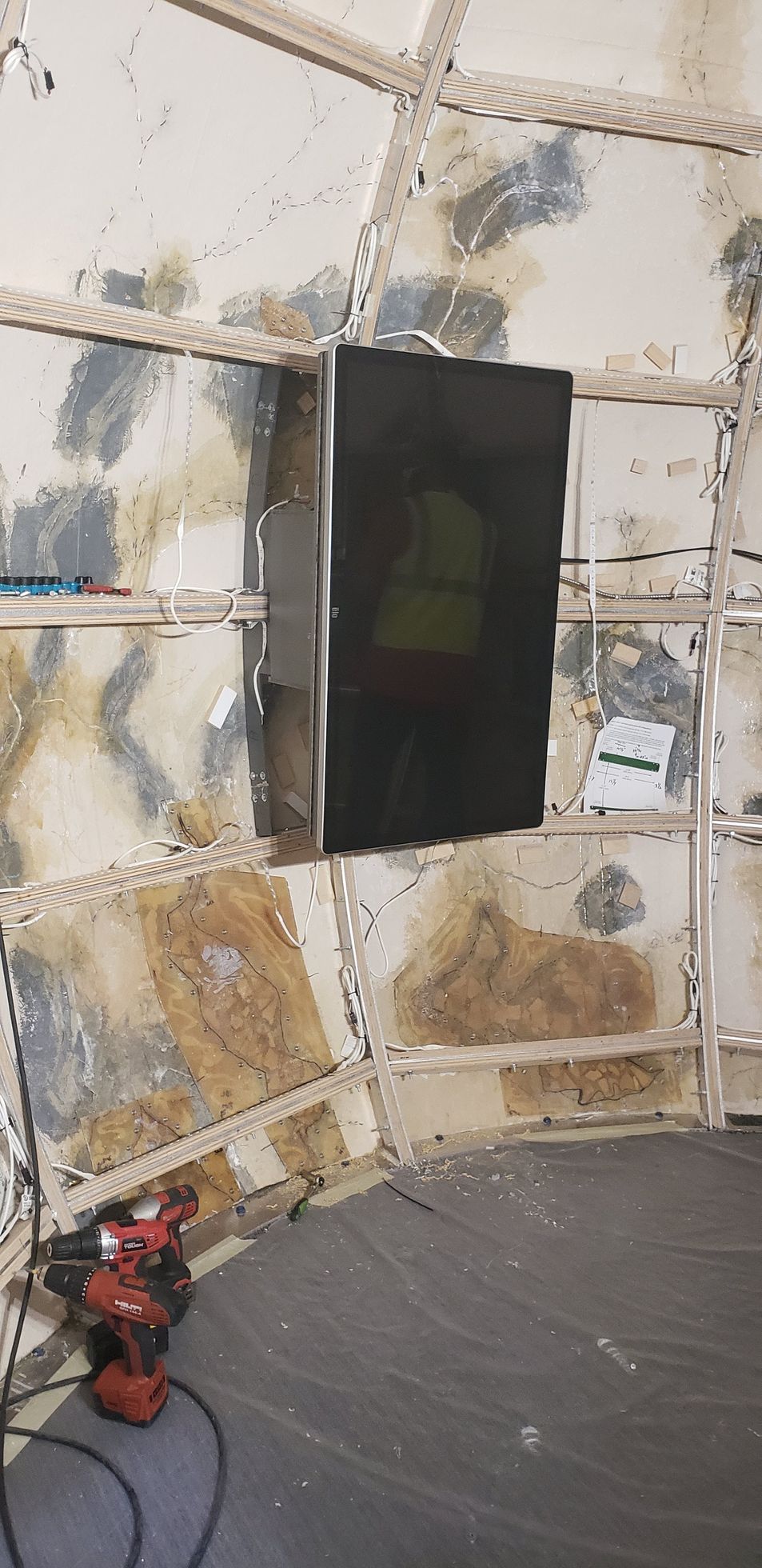 A room with a ladder and a box on the wall.