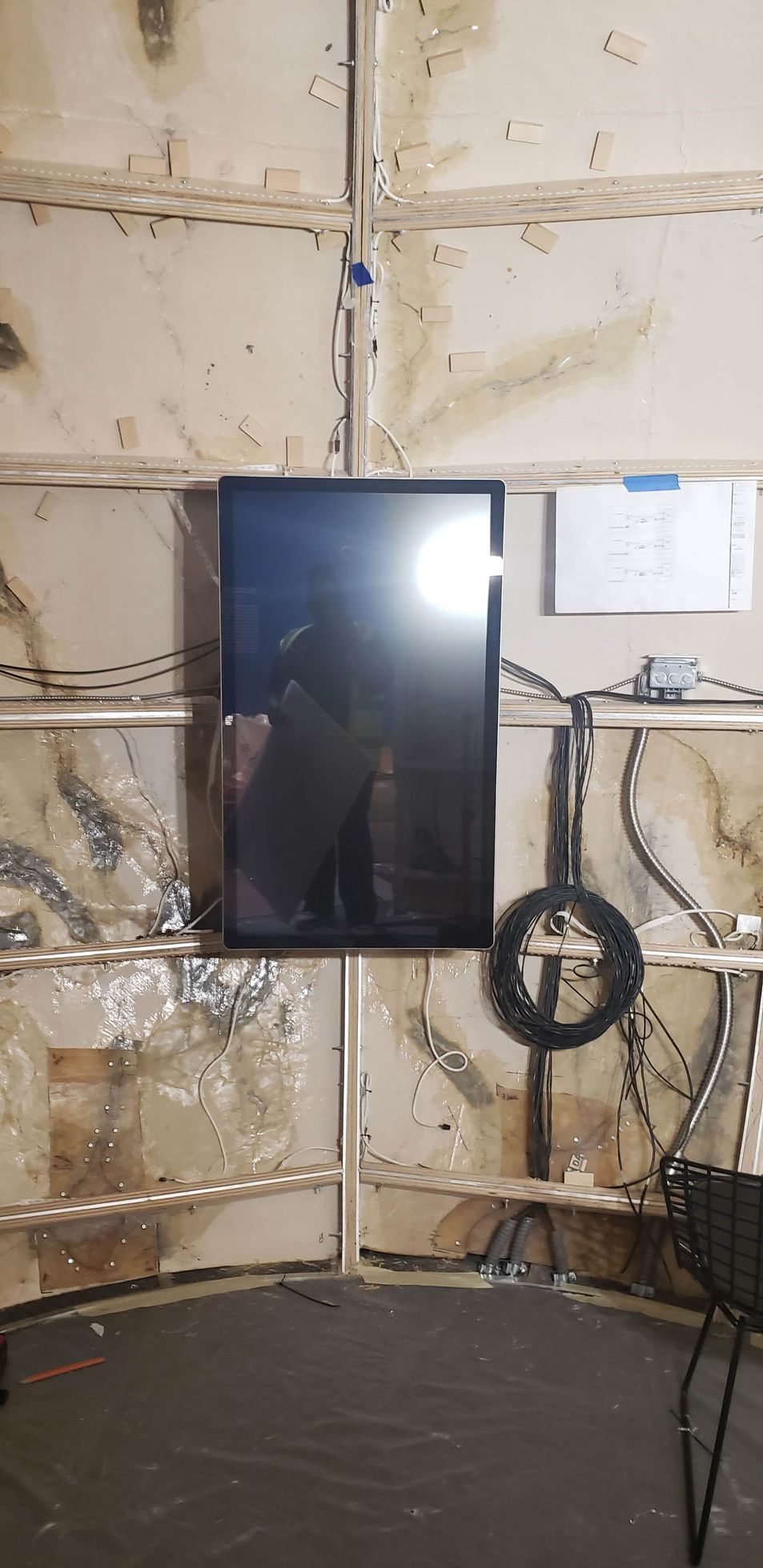 A flat screen tv is hanging on a wall in a room.