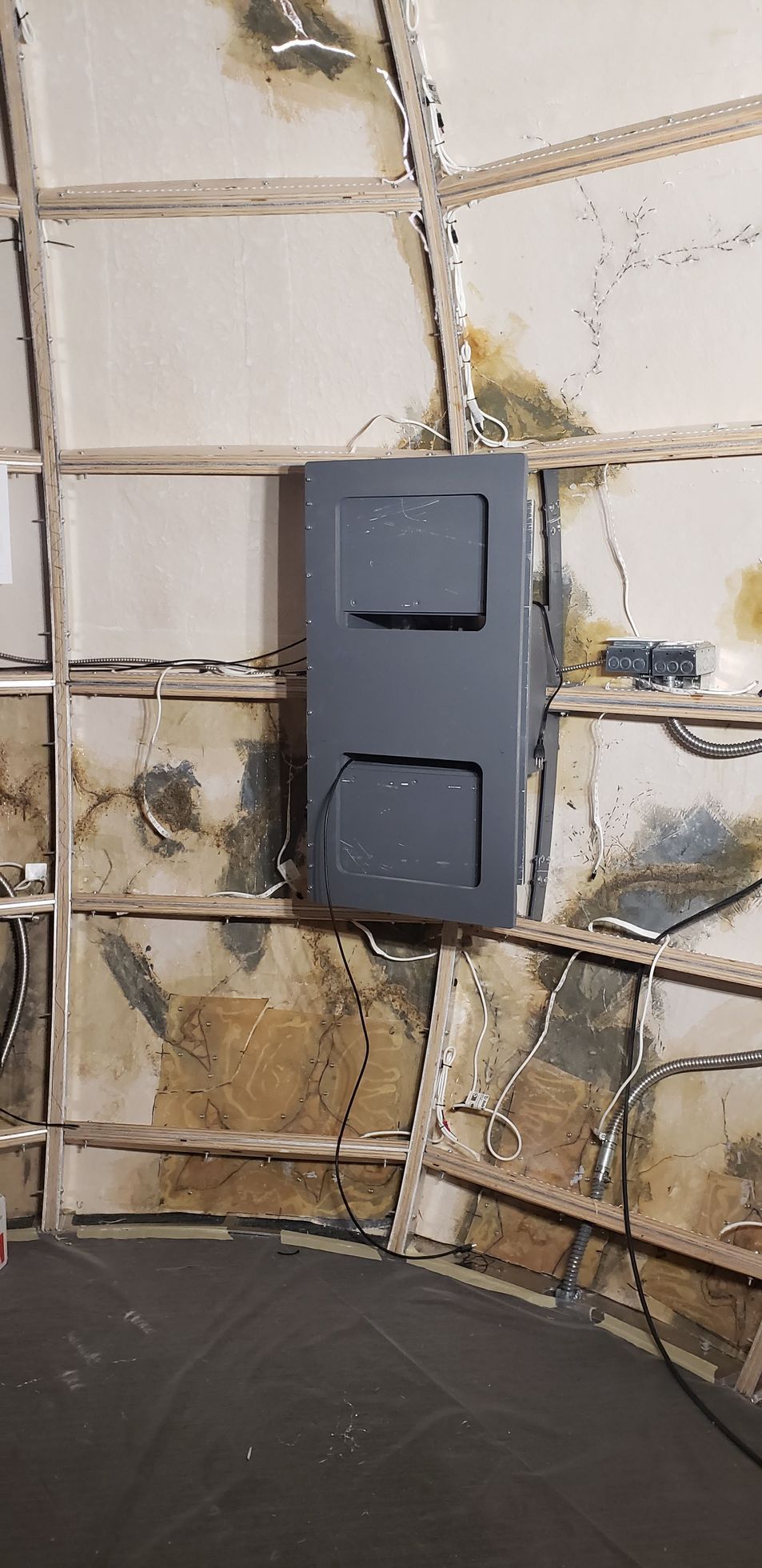 A black box is hanging on a wall in a room.