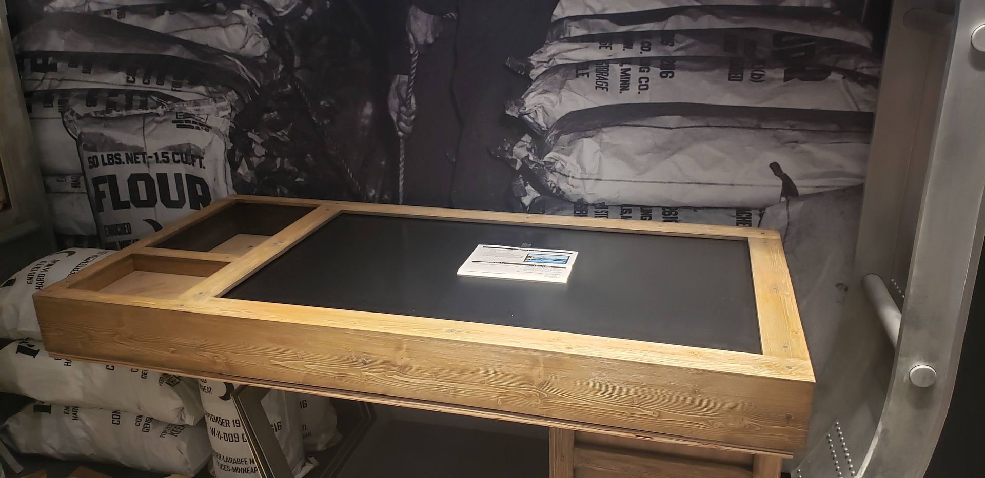 A table in a room with a bag of flour in the background.