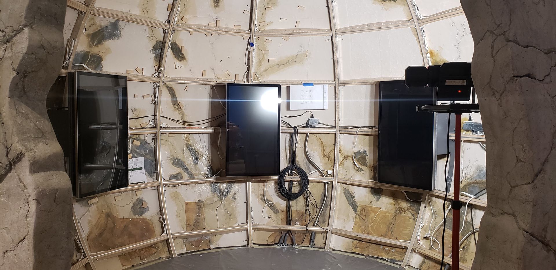 A room with a lot of televisions on the wall