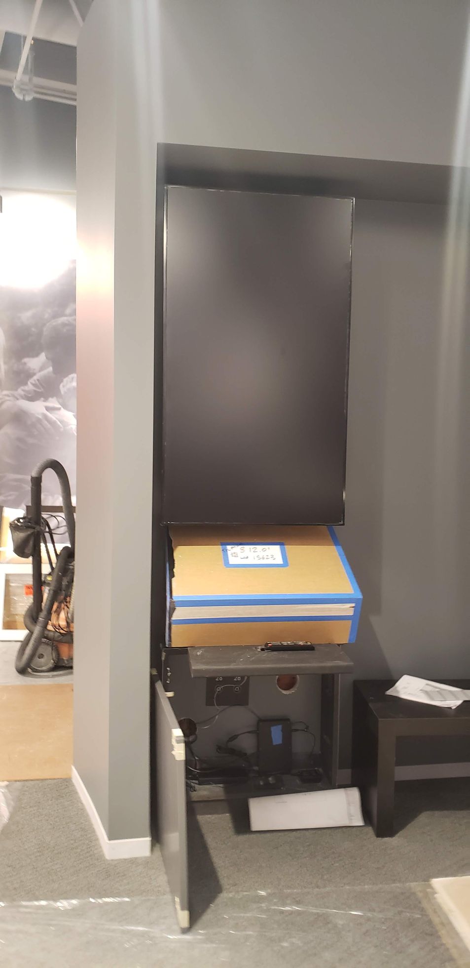 A vacuum cleaner is sitting on a table in a room next to a wall.