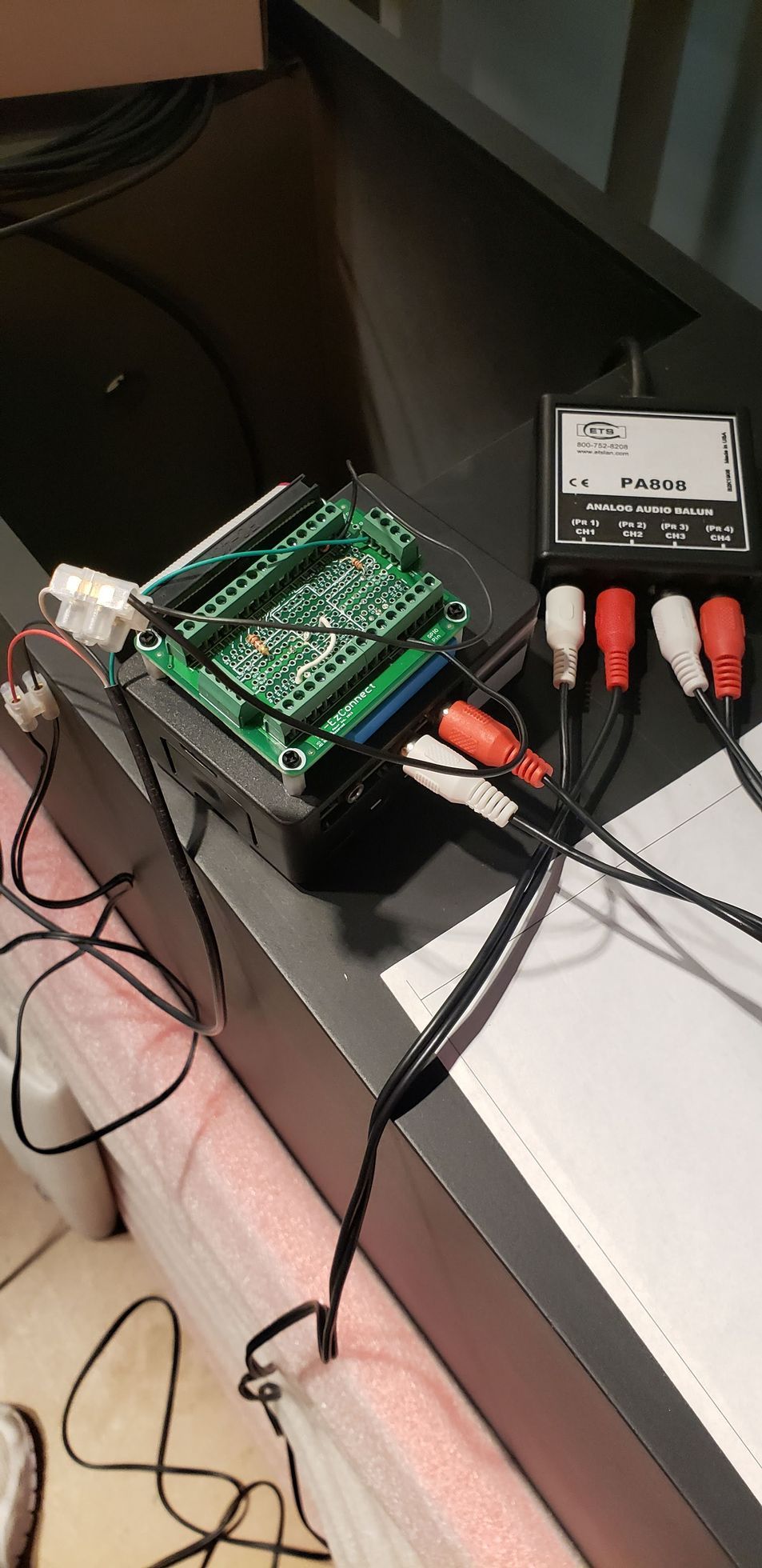 A computer board is sitting on top of a table next to a bunch of wires.