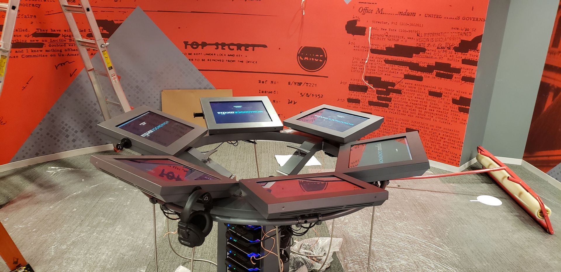 A table with a bunch of computers on it in a room.