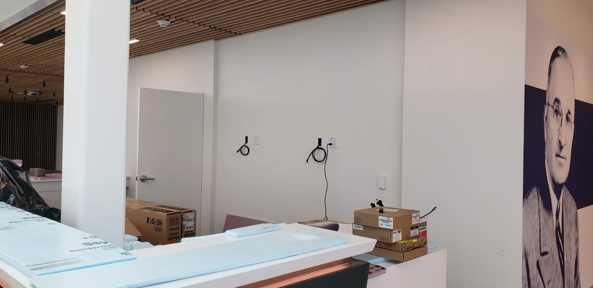 A room with a picture of a man on the wall.